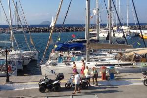 a group of people standing at a marina with boats at Marina Square in Páloi