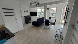 a living room with a table and chairs and a kitchen at Apartamenty Baltic Korona B19 in Darłowo