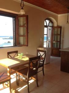 a dining room with a table and chairs and a kitchen at Marina Square in Páloi
