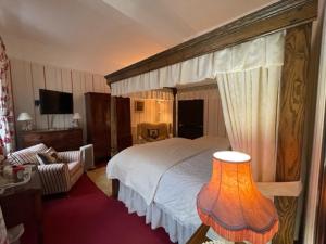 a bedroom with a large bed with a canopy at Barton Hall Country House in Pooley Bridge