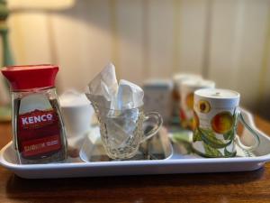 a tray with condiments and a cup on a table at Barton Hall Country House in Pooley Bridge