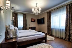 a bedroom with a large bed and a chandelier at Casa Chilia Resort&Spa in Chilia Veche