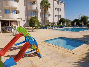 un tobogán infantil frente a una piscina en Mandalena Hotel Apartments, en Protaras