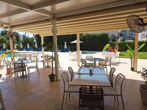 een patio met tafels en stoelen en een zwembad bij Mandalena Hotel Apartments in Protaras