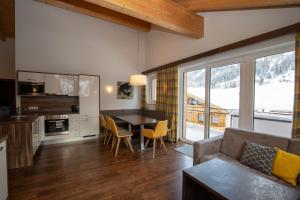 een keuken en woonkamer met een tafel en een bank bij Lux Appartements in Ischgl