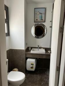 a bathroom with a toilet and a sink and a mirror at Lovely 1BR with Private Heated pool at El-Gouna in Hurghada