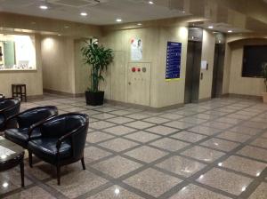 東京にあるスマイルホテル日本橋三越前の椅子と壁の看板が置かれた待合室