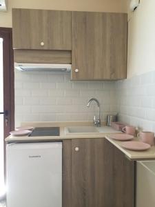 a kitchen with wooden cabinets and a sink and a dishwasher at Casa Rural Abuelo Teo in Campo de Criptana