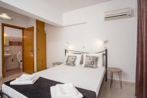 a bedroom with a white bed and a bathroom at Anastasia Apartment in Afantou
