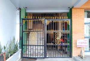 a green and gold gate in front of a building at RedDoorz near Ormoc Port Terminal in Ormoc