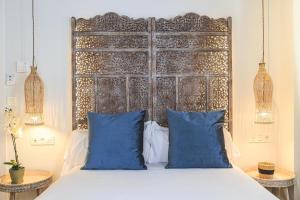 a bed with blue pillows in a bedroom at Hotel La Casa de Los Mosaicos in Granada
