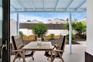 een houten tafel en stoelen op een patio bij Mar Azul Corralejo- Adults Only in Corralejo
