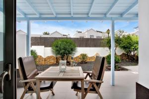 uma mesa de madeira e cadeiras num pátio em Mar Azul Corralejo- Adults Only em Corralejo