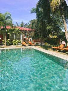 a swimming pool with blue water in front of a house at Green Hill Mirissa in Mirissa