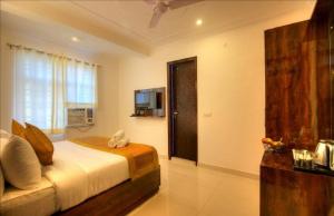 a bedroom with a bed and a television in it at Ark of Avalon Near IGI AirPort New Delhi in New Delhi