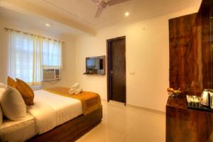 a bedroom with a bed and a television in a room at Ark of Avalon Near IGI AirPort New Delhi in New Delhi