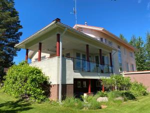 une maison avec un balcon au-dessus dans l'établissement Grand Villa Kivistö near Helsinki airport, à Vantaa