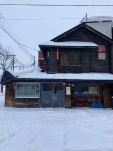 un bâtiment avec de la neige au-dessus dans l'établissement 宿泊×編集事務所×土産物店「あさひかわ編集室」, à Asahikawa