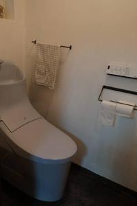La salle de bains est pourvue de toilettes blanches et d'une serviette. dans l'établissement 宿泊×編集事務所×土産物店「あさひかわ編集室」, à Asahikawa