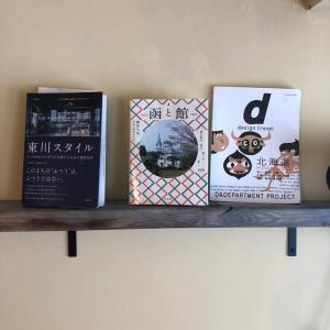 trois livres assis au-dessus d'une étagère dans l'établissement 宿泊×編集事務所×土産物店「あさひかわ編集室」, à Asahikawa