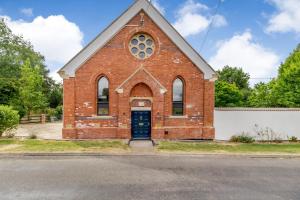a red brick church with a black door at Old Chapel in Gainsborough