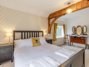a bedroom with a large white bed and a desk at Old Chapel in Gainsborough