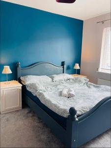 a blue bedroom with a bed with a blue wall at Mia Property in Bristol