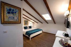 1 dormitorio con 1 cama y una pintura en la pared en Hanul Marioarei en Roman