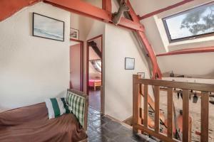 a room with a bed and a staircase with a window at Gîte typique pour 6 à Rochefort-en-terre in Rochefort-en-Terre