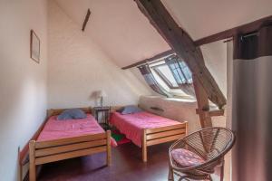 a small room with two beds and a chair at Gîte typique pour 6 à Rochefort-en-terre in Rochefort-en-Terre