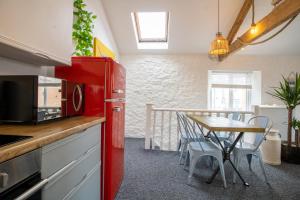 a kitchen with a red refrigerator and a table at Cozy, Chic, Dairy Cottage near to Beach & Shops- Parking in Torquay