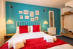a bedroom with a large white bed with red pillows at Cozy, Chic, Dairy Cottage near to Beach & Shops- Parking in Torquay