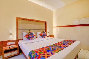 FabExpress Super 7 Inn في مومباي: غرفة نوم مع سرير كبير مع بطانية ملونة