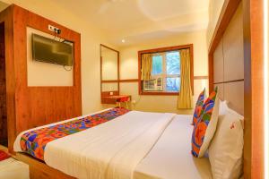 a bedroom with a large bed and a television at FabExpress Super 7 Inn in Mumbai