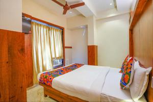 a bedroom with a large bed and a window at FabExpress Super 7 Inn in Mumbai