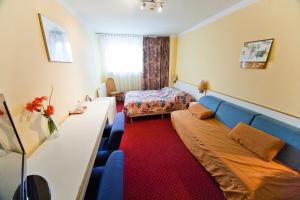 a hotel room with a bed and a couch at Hostel Malinowski City in Gliwice