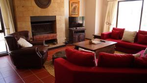 sala de estar con muebles de color rojo y chimenea en Nyikani Villa Olpejeta, en Nanyuki
