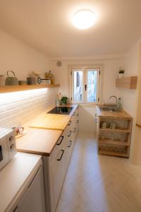 a kitchen with white cabinets and a counter top at Rosalia Apartment in Koper