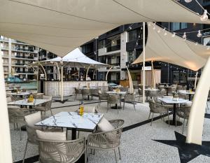 een patio met tafels en stoelen en een gebouw bij Apartament de poveste pe plajă în Resort de Lux in Năvodari