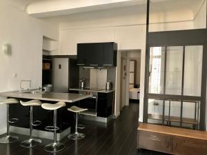 a kitchen with a counter and bar stools at Le portalet centre historique in Hyères