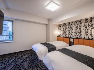 una camera d'albergo con due letti e una finestra di APA Hotel Asakusabashi Ekimae a Tokyo