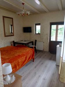 1 dormitorio con cama, mesa y TV en Gościniec Zośka, en Ostrzyce