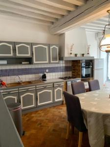 a kitchen with a table and chairs and a kitchen with white cabinets at La tour de Jade in Avallon