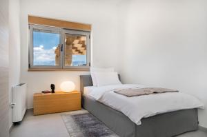 a bedroom with a bed and a window at Luxury villas on Island Pag - Plant Villas Novalja in Novalja