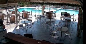 a swimming pool with tables and chairs next to a swimming pool at TRA MANNA in Lecci