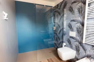 La salle de bains est pourvue de toilettes et d'un mur bleu. dans l'établissement Agriturismo Tiare dal Gorc, à Gorgo