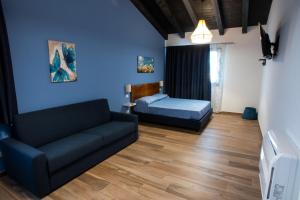 - un salon avec un canapé et un lit dans l'établissement Agriturismo Tiare dal Gorc, à Gorgo