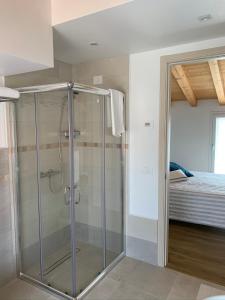 a glass shower in a bedroom with a bed at Villavecchia in Castegnero