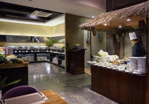 a chef standing at the counter of a restaurant at G Mekong Hotel Phom Penh in Phnom Penh