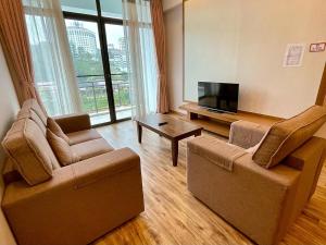 een woonkamer met 2 stoelen en een flatscreen-tv bij PLAY at Nova Retreat Kea Farm in Cameron Highlands